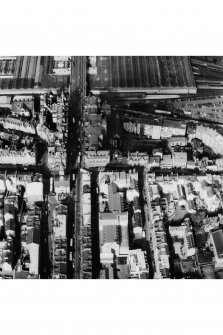 Oblique aerial view of centre of Edinburgh including High Street running left to right across centre of photograph and North and South Bridges running top to bottom