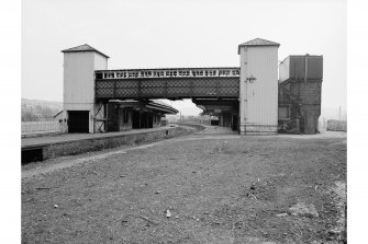 View from N showing footbridge, water tower and station buildings, Hawick railway station
