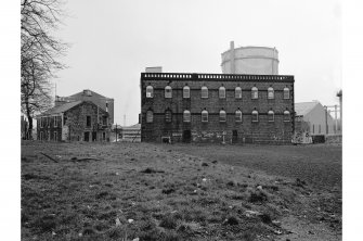 Paisley Gasworks
View of 3-storey, 9-bay building with round-headed windows (foreground) and gas-holder (background)