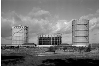 North area of Granton Gasworks, Edinburgh.
General view from S of gasholders 2, 1 and 3 with Meter House (left) and Pumping Station (right). The red brick structure (right) is the remains of the redundant cooling water pumps. This has lost its wooden cooling tower. Left and right structures since demolished.