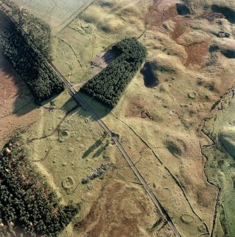 Oblique aerial view centred on the remains of hut circles, small cairns, banks and huts with farmstead, small cairns and rig adjacent at Rottal, Glen Clova, taken from the N.
