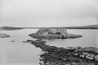 View of broch from the shore looking along the causeway, Dun Torcuill, Loch An Duin, North Uist.
Photographed by Erskine Beveridge in 1897.
