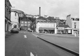 Oban, Oban Distillery
View from W showing WSW front of numbers 60-68 George Street and WSW front of distillery office block with maltings and chimney in background