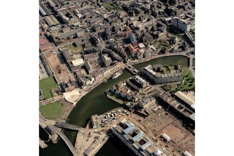 Oblique aerial view, taken from the NW, showing North Leith across the top half of the photograph, and Customs House and the East Old Dock and swing bridge in the bottom half. The Victoria swing bridge is visible in the bottom left-hand corner.