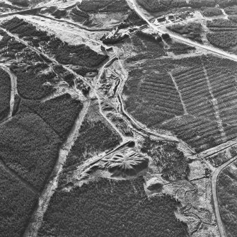 Scanned image of oblique aerial view, taken from the NE, showing the bings of two coal mines at the bottom, and the remains of ironworks, workers' rows, lime kilns, coke ovens and buildings across the remainder of the photograph, including a large area of bell pits in the centre and top left-hand corner.