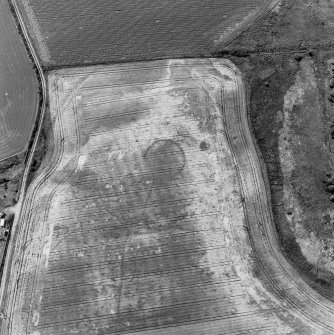 Gilchrist, oblique aerial view, taken from the NE, centred on the cropmarks of a possible enclosure and a round house.