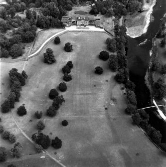 Oblique aerial view, taken from the WSW, centred on the country house, formal gardens and stables.