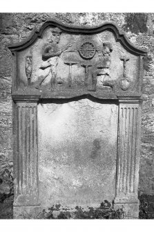 View of gravestone 'Marion McKenzie d.1767' (Ross) showing carved tools and two figures, possibly surveying. 
