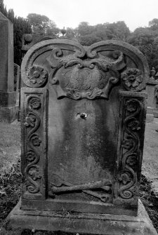Edinburgh, Dell Road, Colinton, Colinton Parish Church, Churchyard.
View of West face of Gravestone of James Brown, 1743, with floral pediment and pillars, a crossed leg-bone and spade, and a scroll inscribed with initials.