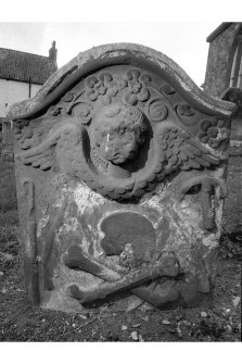 Bolton churchyard.
William Lamb d. 1724. Reverse face; large winged cherub, flowers. Skull, crossbones and tools of slater below.