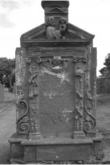 Stenton churchyard.
Inscription illegible. East face; portrait of gentleman holding skull in pediment. Inscription panel bordered by various emblems of death and mortality.