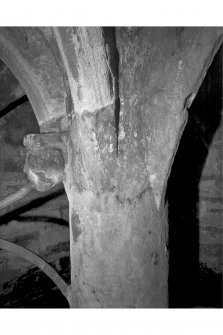 Detail of pillar showing the profile of the carved stone head well mouth, and with the mason's mark visible.