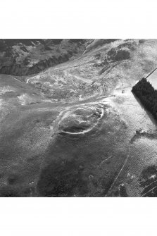 Snaip Hill, oblique aerial view, taken from the N, centred on the remains of fort, with an enclosure and possible hut circle to the left of the photograph.