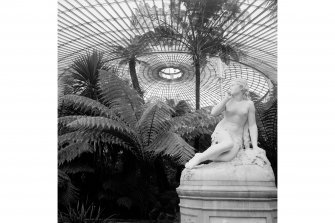 Statue, plants and roof structure in Kibble Palace, Botanic Gardens, Glasgow.