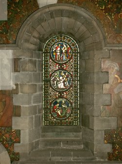 Interior. North chapel, stained glass window on north wall showing scenes from the lives of the Saints.
