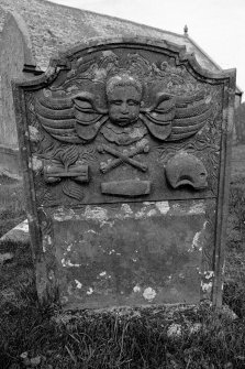 Gravestone commemorating Ann Williamson, d.1780. Winged cherub; winged hourglass, crossbones, coffin, skull in profile.