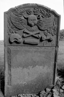 Gravestone commemorating Elizabeth McKittrick, d.1751. Winged cherub; skull in profile, crossbones, coffin, winged hourglass.