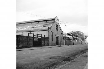 View from W showing SW front and part of NW front of E block of iron works with Roxburgh Works workshops in background