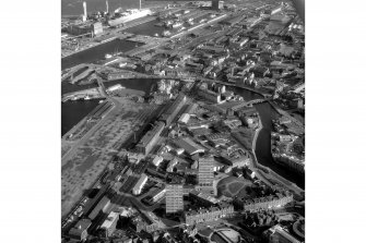 Scanned image of an oblique aerial view showing part of the docks and a view to Arthur's Seat..