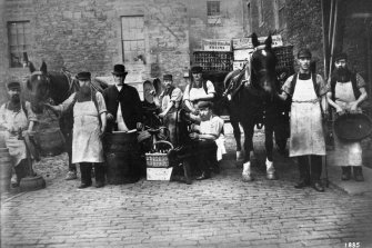 Edinburgh, 87 Giles Street, The Black Vaults.
View of the courtyard with a group of men in aprons and holding coopers equipment and holding horses.
Insc: '1885'.