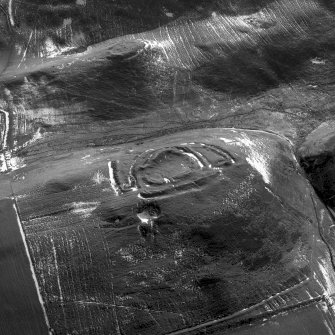 Cow Castle, oblique aerial view, taken from the NW, centred on a fort and settlement site, with Langloch Knowe fort and cultivation terraces to the top of the photograph.