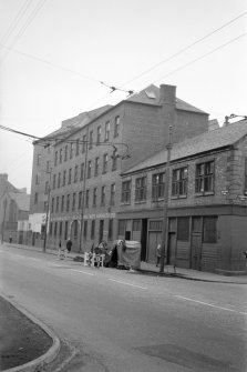 Glasgow, 50 Commercial Road, New Adelphi Mill
View from S showing SW front of corner block of New Adelphi Mill with Hosiery Works in background