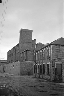 Glasgow, 177 Reid Street, Barrowfield Spinning Factory
View from SW showing part of WNW and SSW fronts of mill with NW block of oil works in foreground