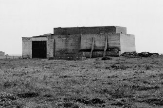 View from North of standby power station with an oil barrel suppport in front.