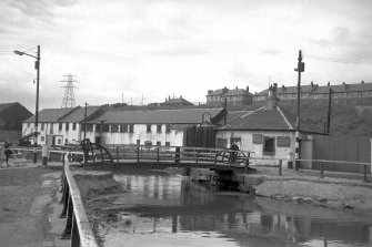 View from SSE showing SE front of bridge with bridgekeeper's cottage and canal workshops in background