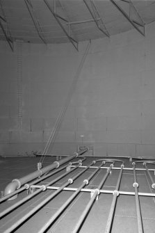 Circular oil-storage tank, interior.
Detail showing steam pipes on the floor and floating outlet pipe.