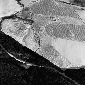 Oblique aerial view centred on the remains of the homestead and field-system, with the remains of the hut-circle, homestead, and building adjacent, taken from the WNW.