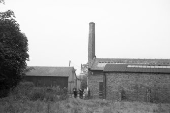 View from NE showing part of ENE front of main blocks with S block and chimney in background