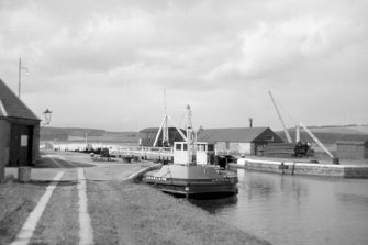 View from SSE showing workboat at N end of Muirtown Basin with smithy on left and crab winch and workshops in background