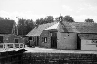 View looking WSW over lock showing E front and part of NE front of workshops with part of smithy on left