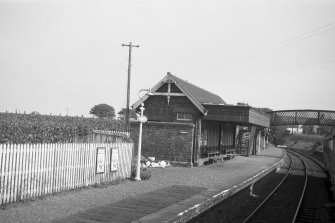 View from SSW showing SW and SE fronts of N building with part of footbridge in background