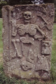 Detail of slab bearing relief King of Terrors, surrounded by emblems of mortality.