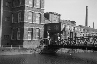 View from W showing part of WNW front of bridge with part of domestic finishing mill on left and other blocks on right