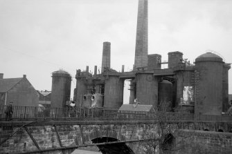 View from SE showing part of railway viaduct with blast furnaces in background