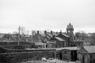 View from N showing NNE and WNW fronts of Station Cottage with Ironworks Cottages and Institute in background