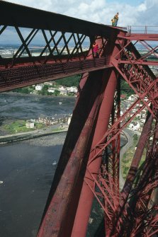Forth Bridge:  Detailed view within the top area of the Fife Cantilever, with North Queensferry below, and the Forth Bridge Inspector standing on top of the cantilever for scale