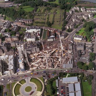 Oblique aerial view of Edinburgh centred on the Parliament site under construction, including Queensberry House and 'Our Dynamic Earth'.