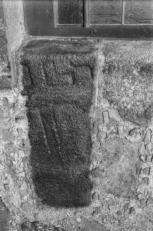 Cross-incised stone reused as jamb of church window.
Original negative captioned: "30 inches long 12 in. broad 8 in. thick to woodwork of window frame. Sculptured stone in North East Window of Parish Church, Ellon 1910'.

