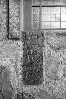 Cross-incised stone reused as jamb of church window.
Original negative captioned: 'Sculptured stone in North-East Window of Parish Church Ellon 1910 / 2 ft. 6 inches long 1 ft. broad 8 in. thick to edge of window frame.".
