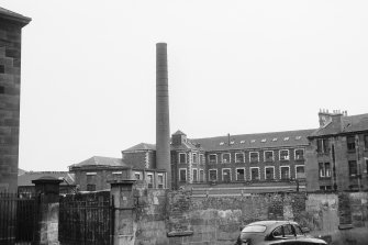 View from N showing part of NE front of main block with chimney in foreground