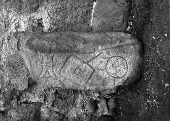 View of Pictish symbol stone, displaying mirror-case, 'shield and spear', and double-crescent symbols.
Original negative captioned 'Sculptured Stone at Newton of Lewesk, Rayne July 1915'.