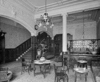 Interior - view of Reception area with tables and chairs, and staircase on left