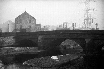 View from SW showing part of WSW front of bridge with mill in background