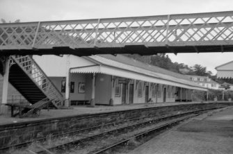 View from W showing SSW front of up platform building with part of footbridge in foreground