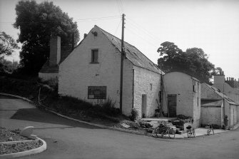 View from N showing WNW front and part of NNE front of mill with building in background