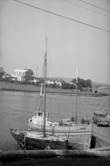 View from S showing boats docked at harbour with part of creamery in background